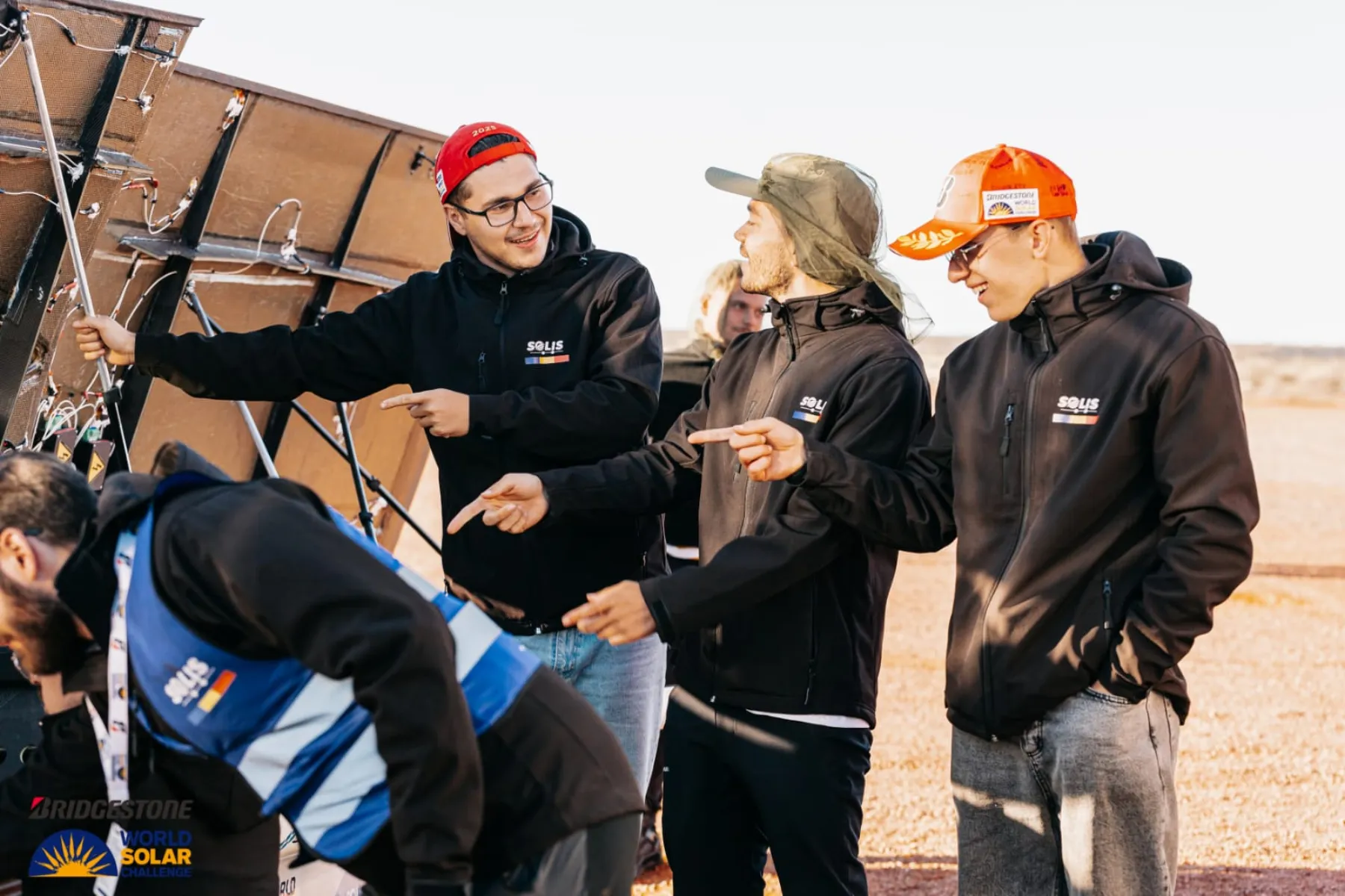 The Solis team tilting the car's solar array toward the sun at an Outback stop
